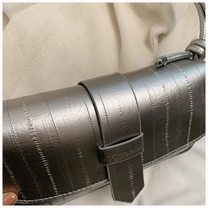 Detailed macro view of silver metallic textured crossbody bag with vertical grain finish
