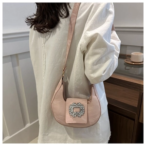 Detailed view of a pink crescent hobo bag featuring a large sparkling rhinestone buckle