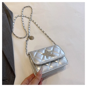 Detail of silver quilted crossbody bag with a rhinestone star buckle and chain strap