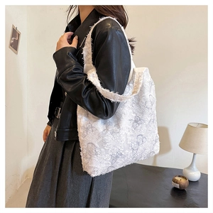 Detailed close-up of white butterfly jacquard pattern and raw edges on a stylish tote bag