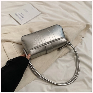 Detail of silver metallic underarm bag with vertical stitching and thin shoulder strap