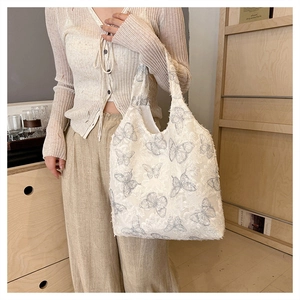 Detail of white butterfly hobo bag with floral lace embroidery and frayed edge design