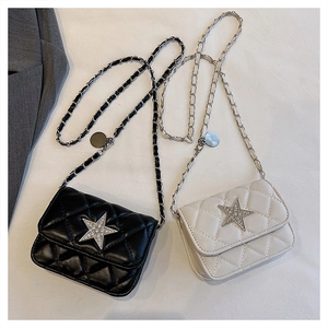 Detail of quilted cross-body bag featuring diamond pattern and sparkling star embellishment