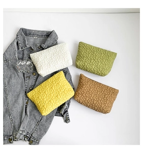Detail of four colorful quilted floral makeup bags with metal zipper and soft texture