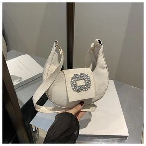 Detail shot of the white hobo bag showing the silver rhinestone buckle and textured leather