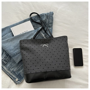 Detail of dark grey canvas tote bag with heart patterns and silver bow metal buckle