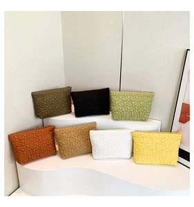 Quilted orange floral envelopes shown in multiple colors on minimalist display tiers