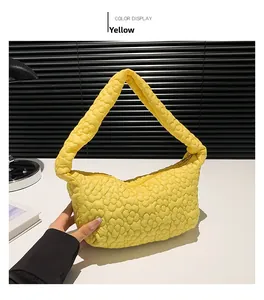Vue détaillée du sac à main matelassé jaune avec texture florale 3D et fermeture