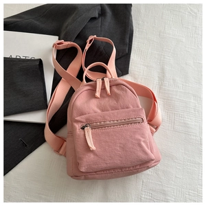 Close-up of pink nylon backpack featuring matte texture and high-quality zipper detail