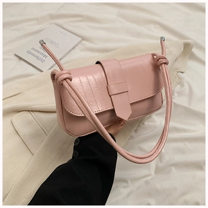 Detail of pink crocodile pattern leather underarm bag with unique shoulder strap knot