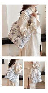 Detail of white tote bag featuring black butterfly print and textured lace material