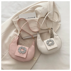 Detail of crescent moon bags in pink and beige with sparkling rhinestone buckle