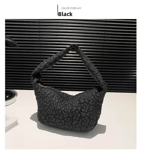 Détail du sac hobo noir avec motif floral matelassé et fermeture éclair fluide