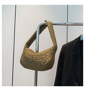 Gros plan sur les motifs floraux matelassés 3D et la texture de ce sac doré chic