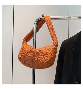 Vue détaillée de la texture fleurie matelassée orange vif sur le sac à bandoulière chic