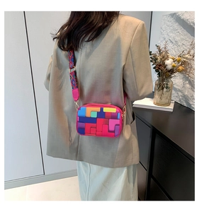 Rear view of a model styling a vibrant rainbow geometric crossbody bag with a wide strap