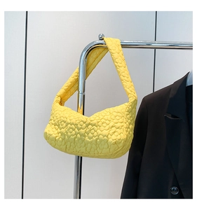 Détail du sac hobo matelassé jaune avec texture florale en relief et large bandoulière