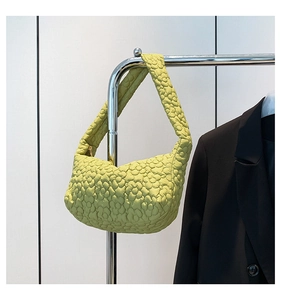 Détail de la texture florale matelassée vert clair sur un sac hobo croissant bouffant