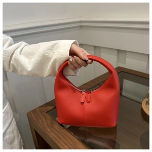 Detail of red hobo bag with silver double zippers and elegant stitching textures