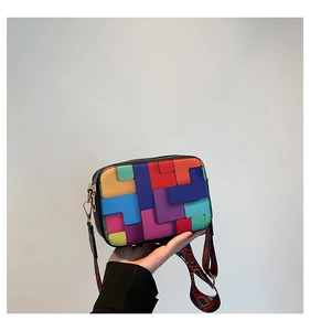 Detail of colorful geometric patchwork crossbody bag with wide ethnic style woven strap