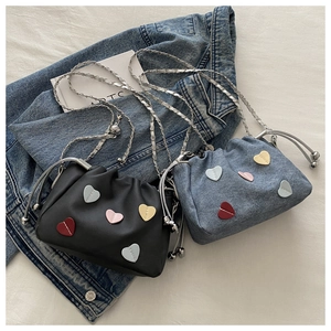 Top view of bucket bags in black leather and blue denim with colorful heart patches