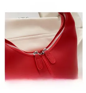 Close-up of red matte leather handbag featuring high-quality silver double zipper closure