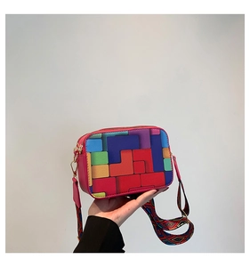 Detail of colorful geometric patchwork crossbody bag with bohemian woven strap