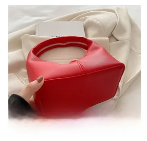 Detailed bottom view of a red matte leather hobo bag showing high-quality stitching