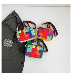 Detailed view of three small square bags with colorful geometric patterns and wide straps