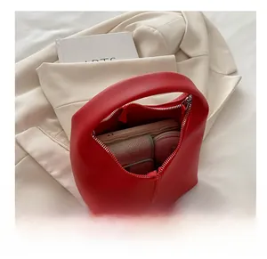 Interior capacity show of red mini tote bag holding phone, wallet and cosmetics