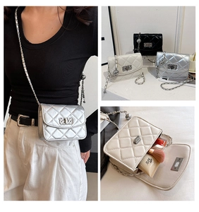 Quilted crossbody bag detail featuring metal chain strap and textured square turn-lock closure