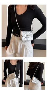 Detailed view of silver quilted chain bag with turn-lock clasp on a fashion model