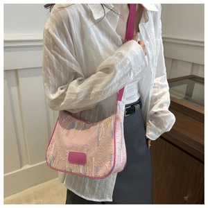 Detailed view of pink nylon dumpling bag featuring colorful embroidery and logo texture