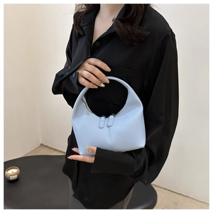 Detail of light blue hobo bag with top handle and double zipper closure in matte faux leather
