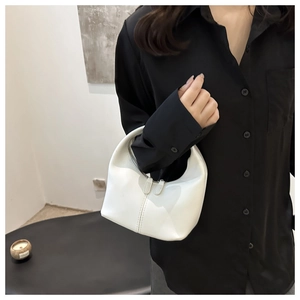 Detail of white half-moon hobo bag with smooth leather texture and vertical stitching