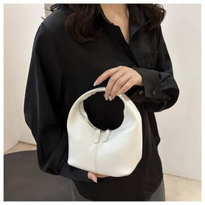 Detail of white half-moon handbag with dual zippers and minimalist stitched seam