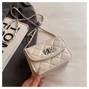 Detail of off-white quilted crossbody bag with silver chain strap and metal lock