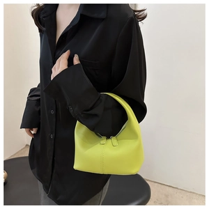 Close-up of a neon yellow crescent hobo handbag with decorative stitching and dual zippers