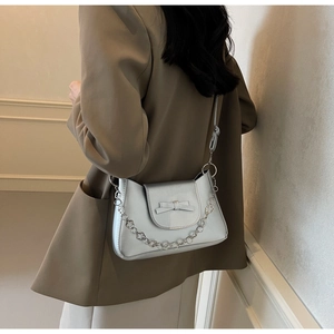 Silver PU leather shoulder bag with metallic bow and decorative chain on the side