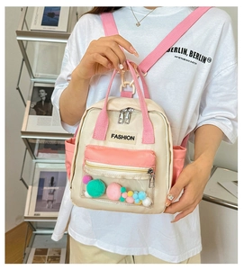 Dettaglio di uno zaino in nylon con tasca in PVC trasparente riempita con pompon colorati