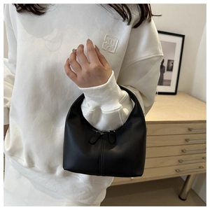 Close-up of minimalist black leather handbag with dual metal zippers for daily wear
