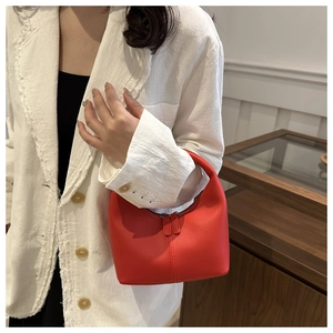Close-up of a mini red leather hobo handbag styled with a white blazer for women
