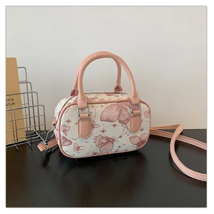Detail of butterfly print texture and pink strap on white boston shoulder bag