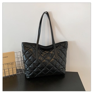 Détail du grand sac cabas noir matelassé avec finition brillante et motifs carrés élégants