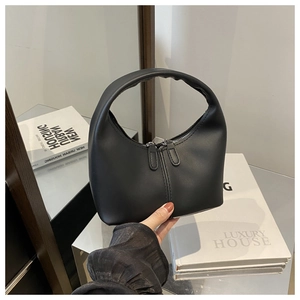 Detailed view of black minimalist half-moon handbag featuring a dual zipper closure system