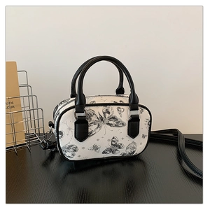 Detail of Boston bag showing ink butterfly print, silver zippers, and black PU handles