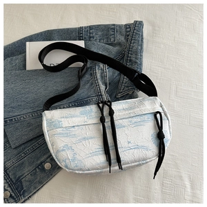 Detail of artistic ink wash pattern and pleated texture on large nylon crossbody bag