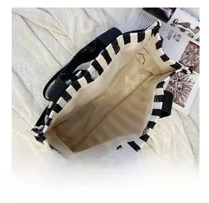 Interior detail of a striped canvas tote bag showing the magnetic snap and fabric lining