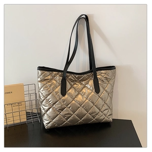 Vue détaillée du sac cabas matelassé or champagne avec des anses en cuir noir robuste