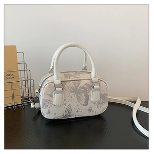 Close-up of white Boston bag with lavender butterfly and constellation prints